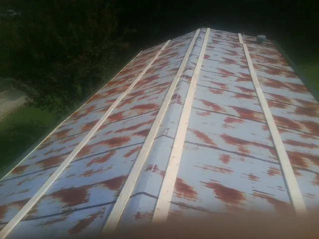 Rusted metal roof panels with new wood purlins before replacement — Storm Damage Roof Repair in Johnstown by Roofing Brothers